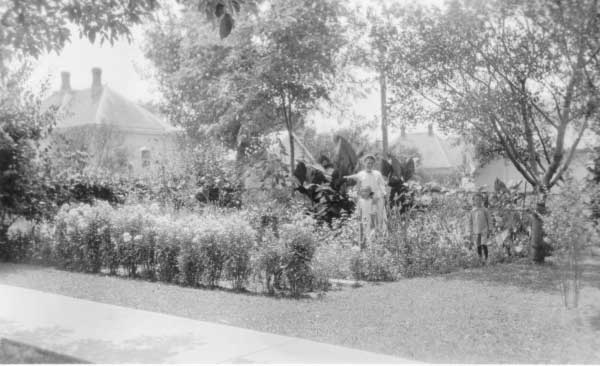 Hattie and daughter Mildred, Roy at flower garden 1618 N street 1921